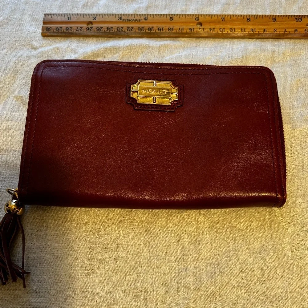 Vintage Monet zip around wallet with tassel on zipper. Maroon in color.